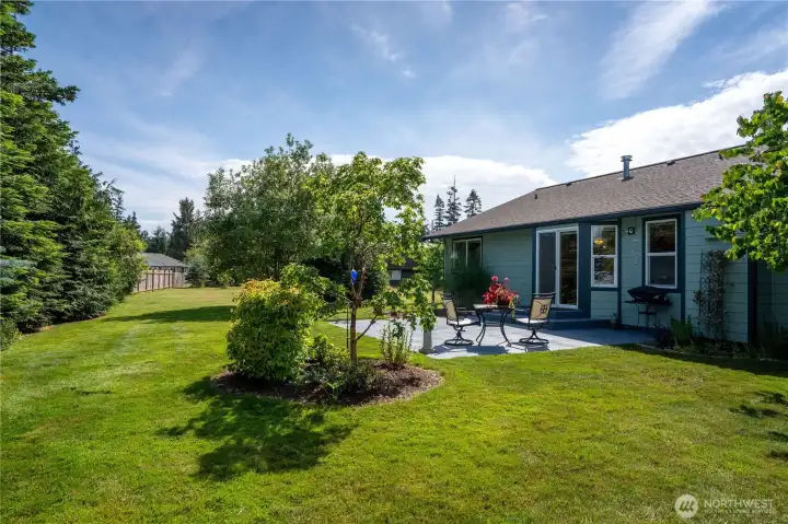 Private backyard with patio, mature landscaping, and room to relax.
