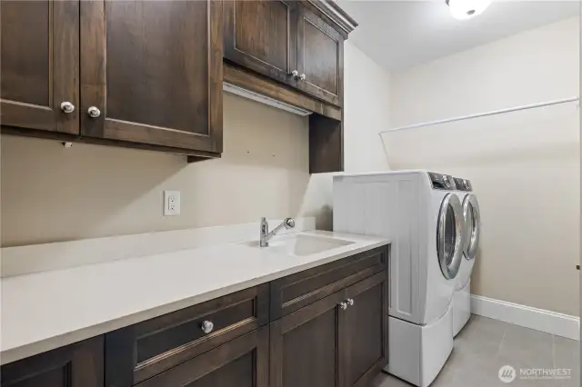 The spacious laundry room features an Electrolux washer and dryer with pedestals (installed in April 2020), offering both functionality and style.