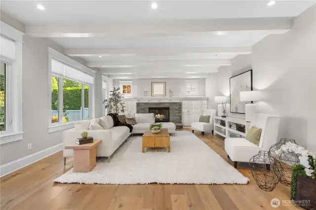 The family room features a cozy gas fireplace, wide-plank oak floors, and a wall of windows that frame sweeping views of the city skyline and its dazzling nighttime lights.