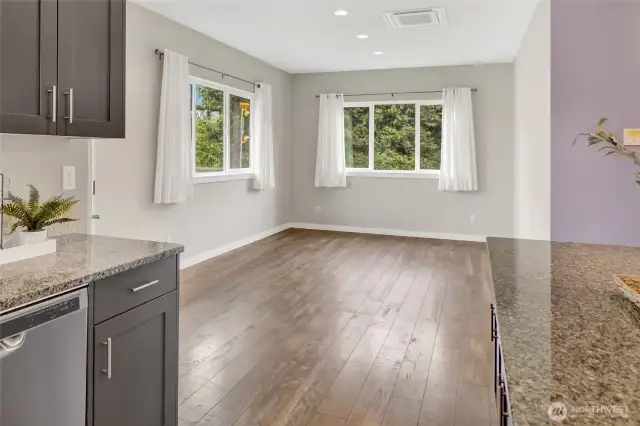 Kitchen open to the dining area that looks onto the side yard and backyard.