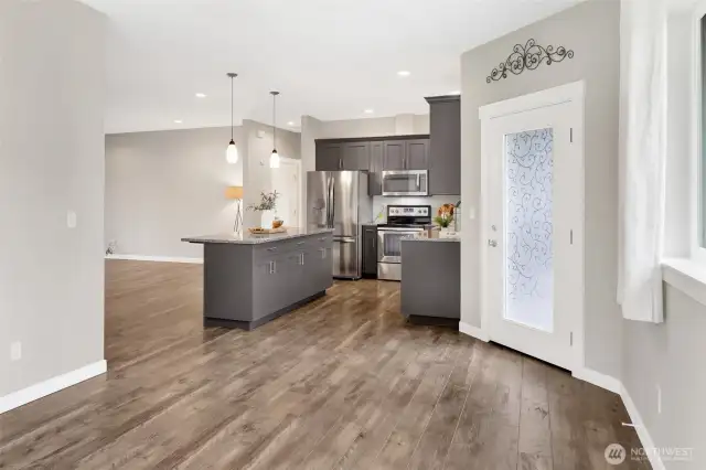 Dining area looking into the kitchen with the door to the backyard and patio.