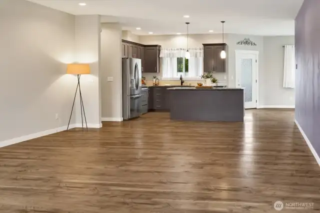 Open floor plan with laminate wood floors and has wonderful light in this home. Open to the kitchen and the dining room with a door out to the backyard patio.