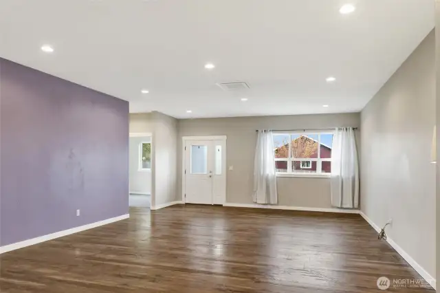 View from the kitchen looking to the front door and large window floods the home with light. The second bedroom to the left faces the street.