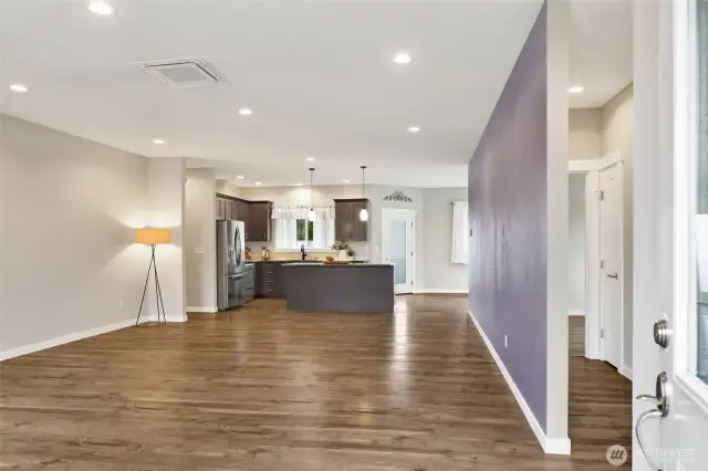 Front door entry into the living room that is open to the kitchen and dining room to the right. The hallway to the right with two bedrooms and full bath separates the two bedrooms in the hall. Entry closet to the right.