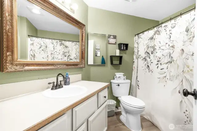 Full bath at end of hallway, next to bedroom.