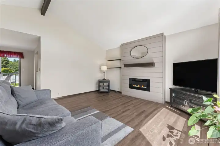 living room features new flooring and a modern electric fireplace