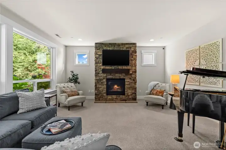 Sunlight fills this elegant room, showcasing mature hydrangeas outside while you unwind in comfort by the warmth of a gas fireplace.