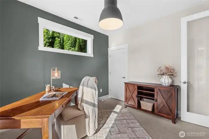 Sunlight filters through the transom window, offering tranquil backyard views, while a well-sized closet ensures a clean and organized workspace.