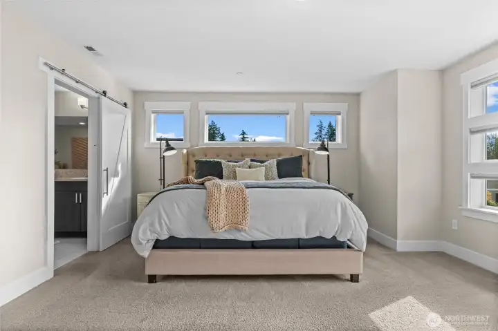 A barn door entry to the bathroom provides privacy while saving space, combining functionality with charming style.