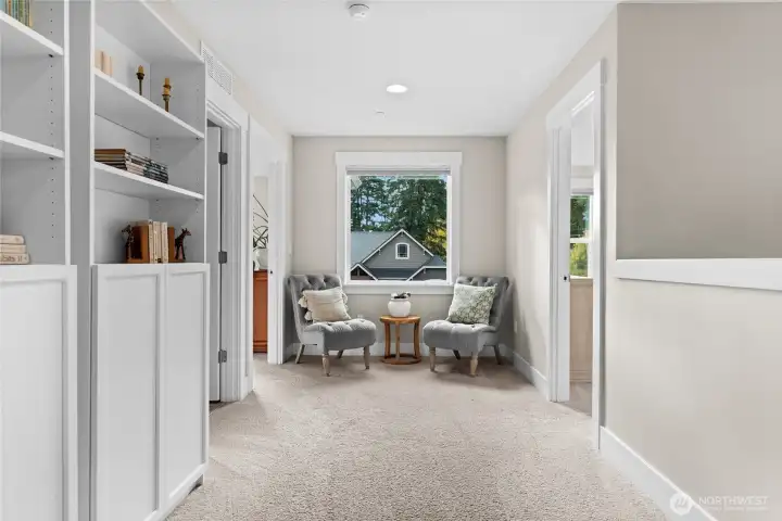 The primary bedroom and a guest suite are tucked at one end of the hall, while the loft and three additional bedrooms occupy the opposite end.