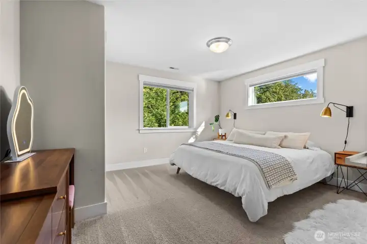 This guest bedroom looks out to a private backyard and also features several windows, including a large transom window.