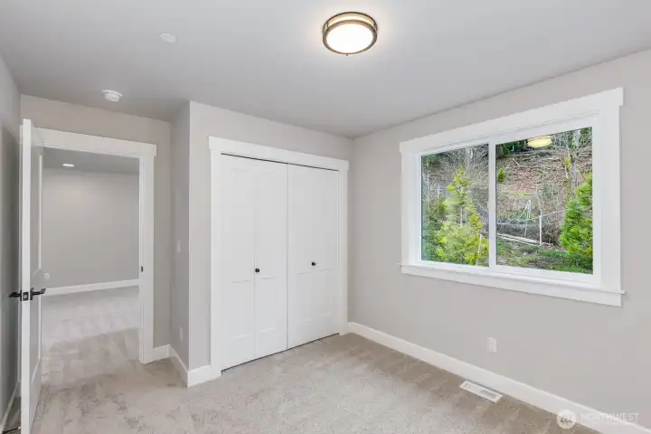 One of 3 upper bedrooms with a peaceful view of nature bordering a green space.