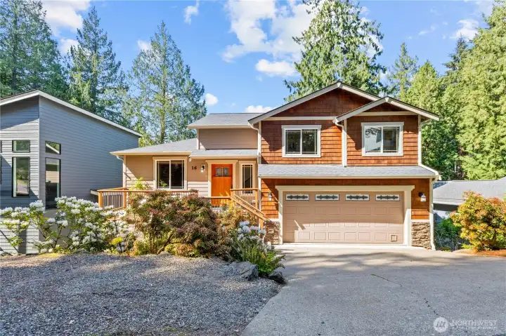 Craftsman-style exterior with mature landscaping, attached garage, and a wooded setting in Sudden Valley.