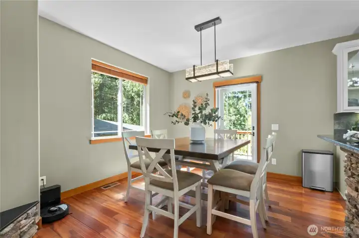 Dining area positioned alongside large windows and deck access, creating a bright setting for meals and gatherings.