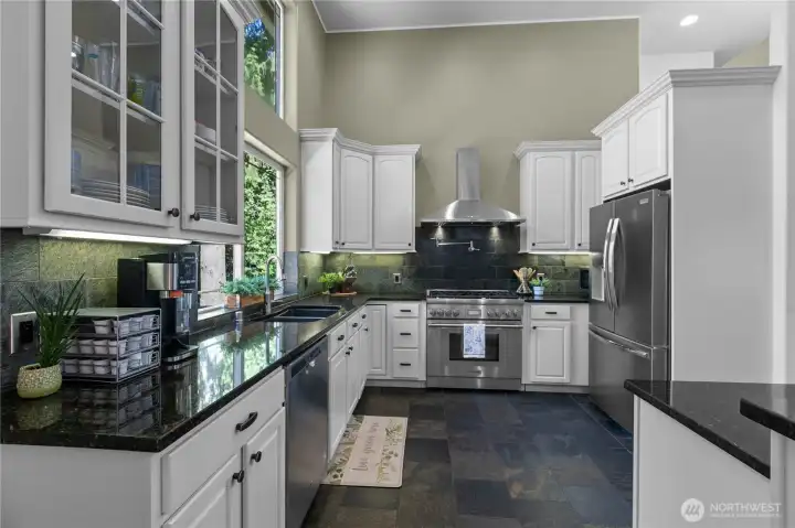 Light-filled kitchen designed for both everyday living and entertaining with expansive prep space and wooded outlooks.