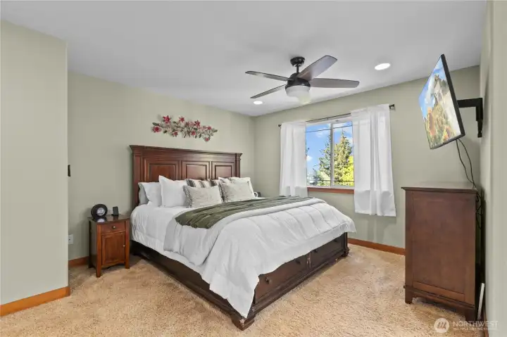 Large primary bedroom filled with natural light and designed for comfort and privacy.