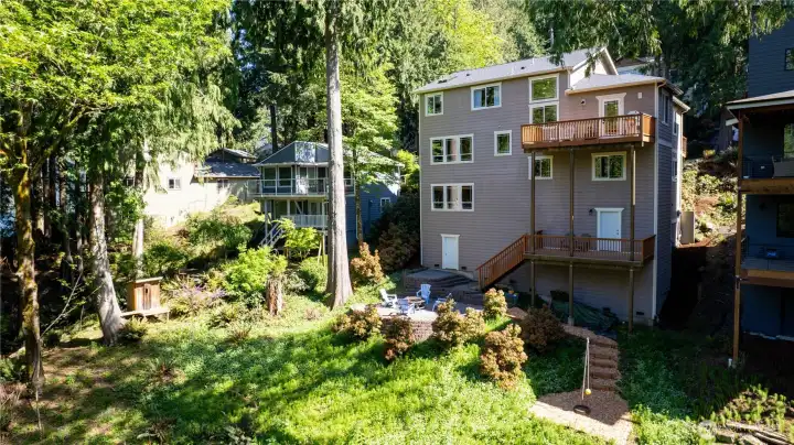 Rear exterior with multiple outdoor living areas designed to enjoy the surrounding natural landscape.