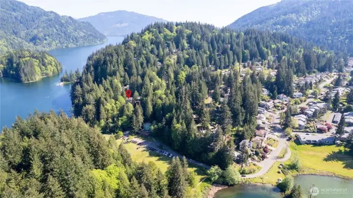 Aerial view showing proximity to Lake Whatcom, nearby AM/PM Beach recreation areas, and surrounding forested setting.