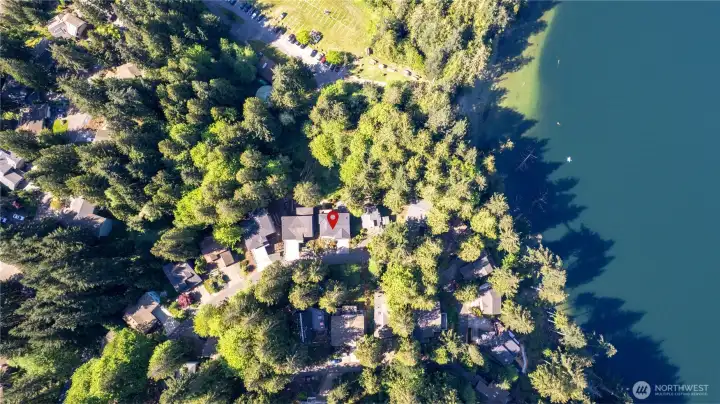 Forested community setting with nearby lake access, trails, and surrounding mountain views.