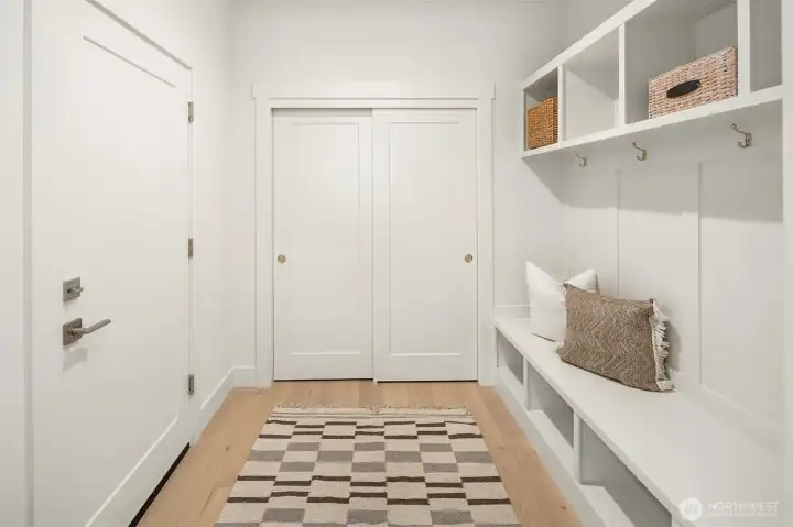 Roomy entry way off of the garage with hall closet and bench with storage space.
