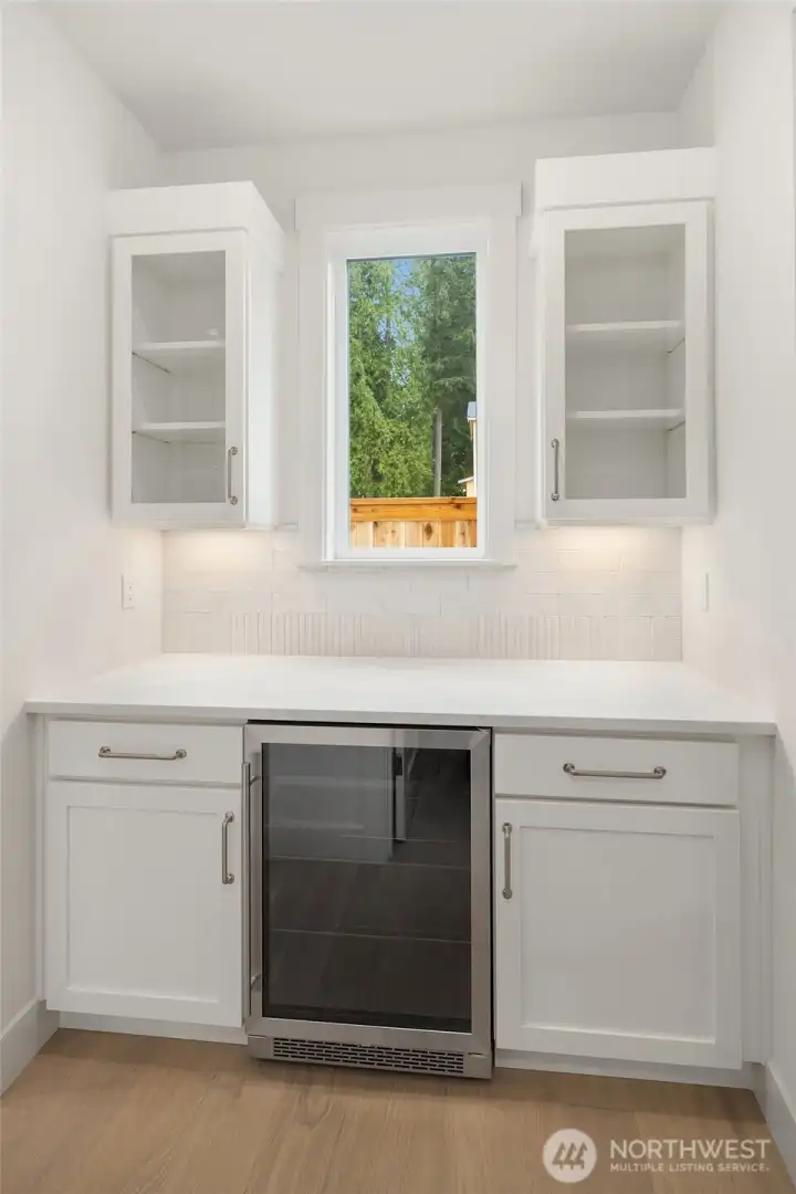 Butler's pantry includes glass cabinets and beverage center.