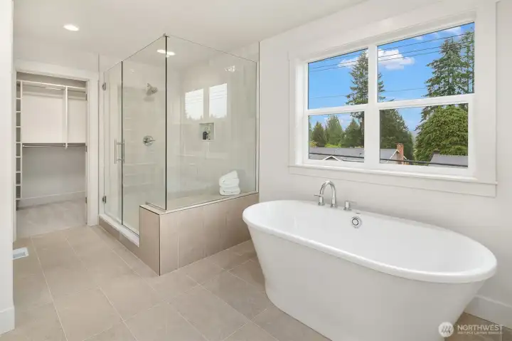 Relaxing stand-alone soaking tub and shower with bench.