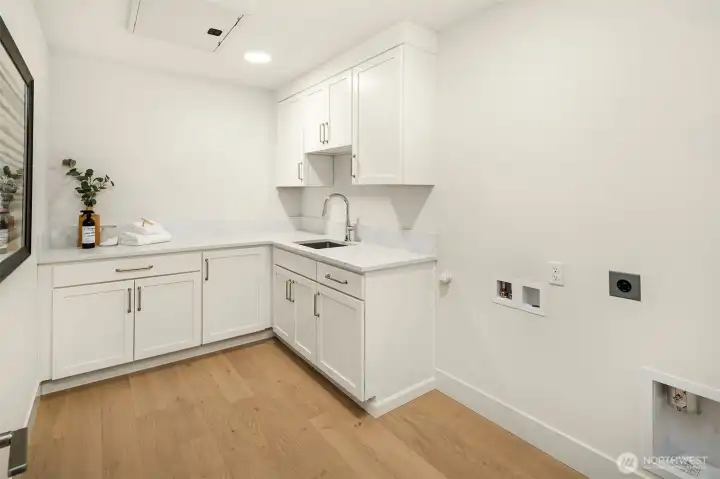 Second story laundry room with cabinets and sink.