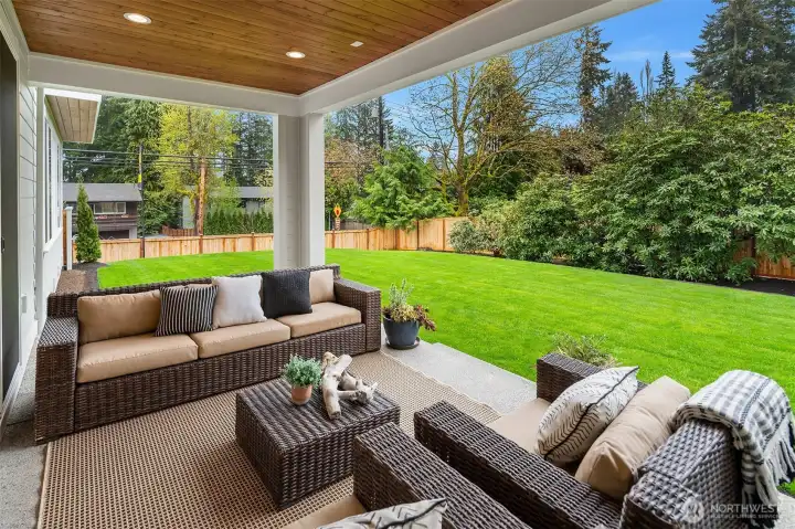 Covered outdoor living area with large, level backyard.