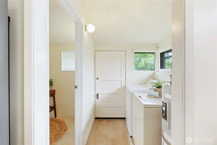 Utility area with bonus room to the left and exit to backyard