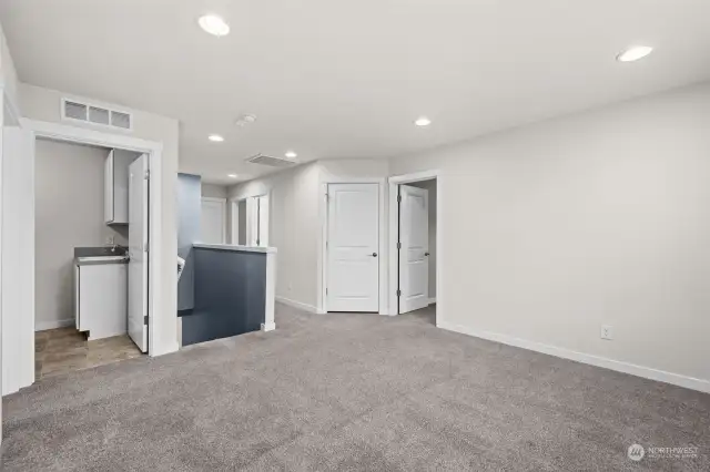 Top of the stairs, you will find this Open and Spacious Bonus Room! Perfect for a hang out area or hobbies! The Room on the left is the Laundry Room. The center darker area in this photo is the staircase going down. Directly on the right of the stairs is the hall to the Main Full Bathroom and 2 additional bedrooms. The First Door on the Right is the 2nd Bedroom and the closed Door at an angle is storage closet and furnace room.