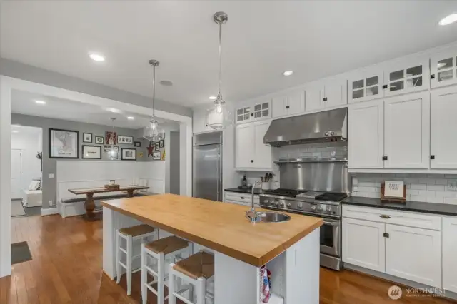 Kitchen features butcher block island with stainless steel bar sink.