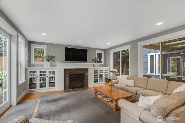 Family room features gas fireplace, built in cabinets, and large windows for natural light.