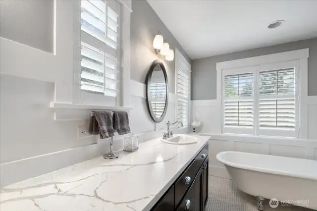 Primary Bath also features craftsman style wainscoting and quartz countertop.