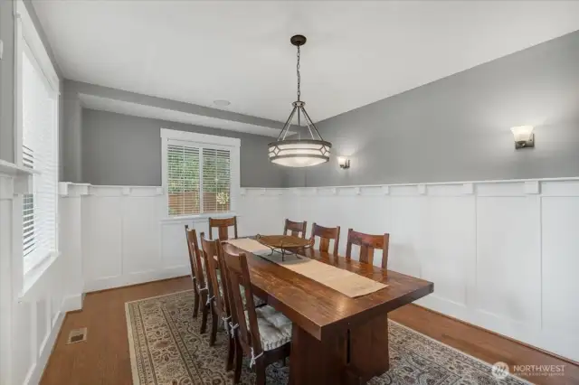 Dining room features craftsman's style wainscoting and hardwood floors.