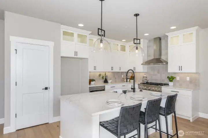 Stunning illuminated glass shelves and accent lighting offers a beautiful space for meal prep and to gather.