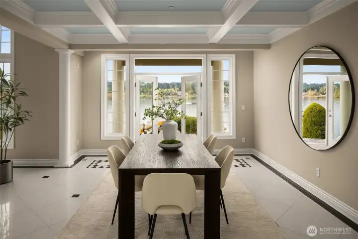 Dining framed by columns and coffered ceilings, aligned to Lake Washington through French doors.