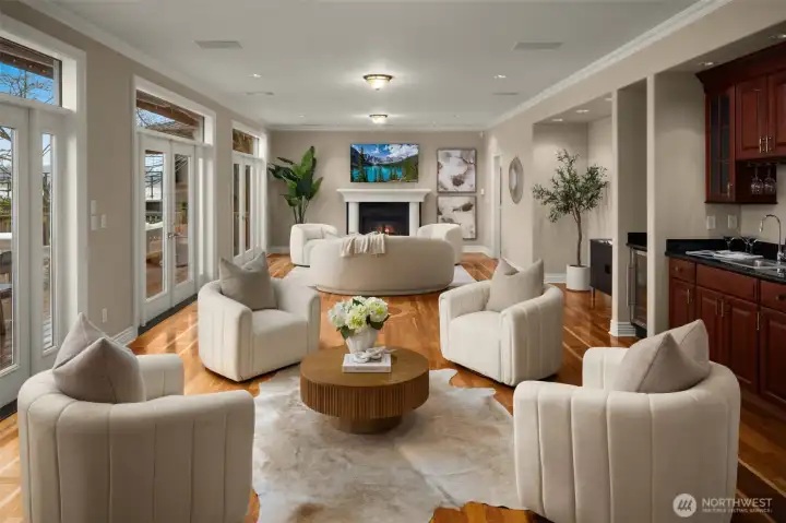 Elegant gathering salon with fireplace and multiple sets of French doors opening to outdoor living.