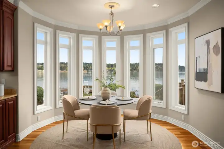 Lake-filled dining nook framed by a wall of windows overlooking the lake.
