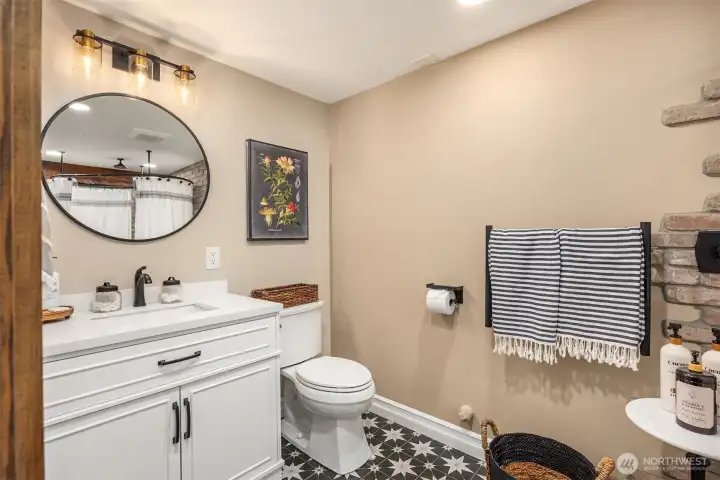 A beautifully finished lower-level bath features modern fixtures and thoughtful design, offering convenience and comfort for guests enjoying the entertainment spaces.