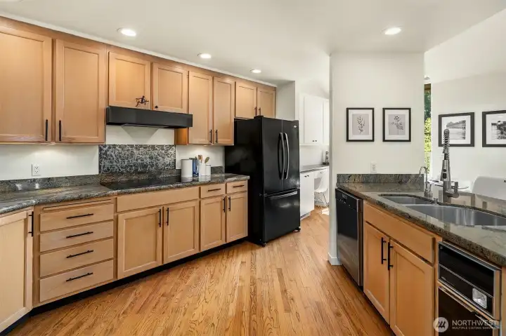 Updated kitchen offers abundant cabinetry with granite stone counters and designer backsplash