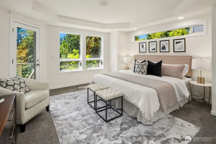 Main floor primary suite is flooded in light and opens to private deck