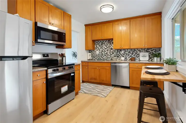 The breakfast bar is on hinges and can fold down & out of the way.  New stainless appliance package just installed.