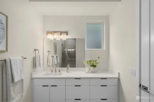 Primary ensuite features white quartz countertops and a ceramic tile walk-in shower.