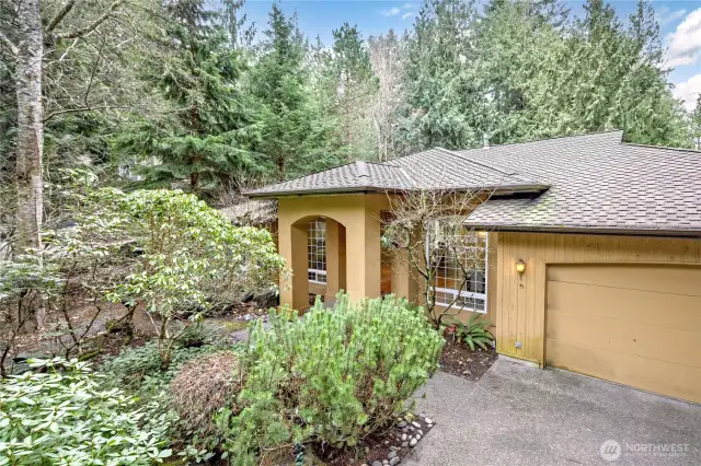 Dramatic entrance that is nestled in a well-established garden.