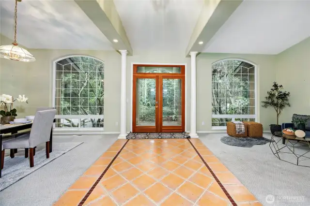 Standing in the entrance looking at the front door.  Sitting area to the right dining area to the left.