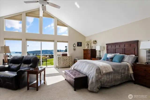 Spacious primary bedroom with large windows, offering breathtaking water views and plenty of room.