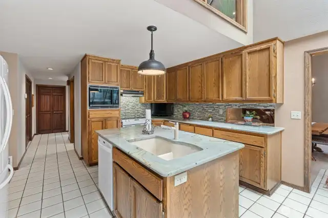 Updated kitchen featuring granite countertops, tile backsplash and Blanco sink. All kitchen appliances will stay!