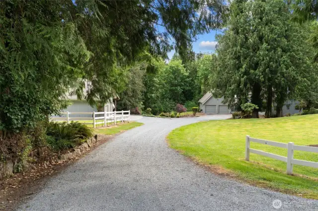 The spacious 5-acre lot includes mature trees, a long gravel driveway, and plenty of room for additional gardening