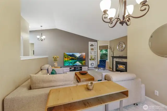 This view captures the full scale of the main living area, perfectly designed for gatherings or quiet evenings. Vaulted ceilings elevate the space, while the fireplace and built-ins enhance both charm and practicality.