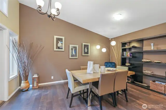 The dining area features warm wood floors, vaulted ceilings, and a contemporary lighting fixture. With ample space and natural light, it’s ideal for hosting friends or enjoying everyday meals.